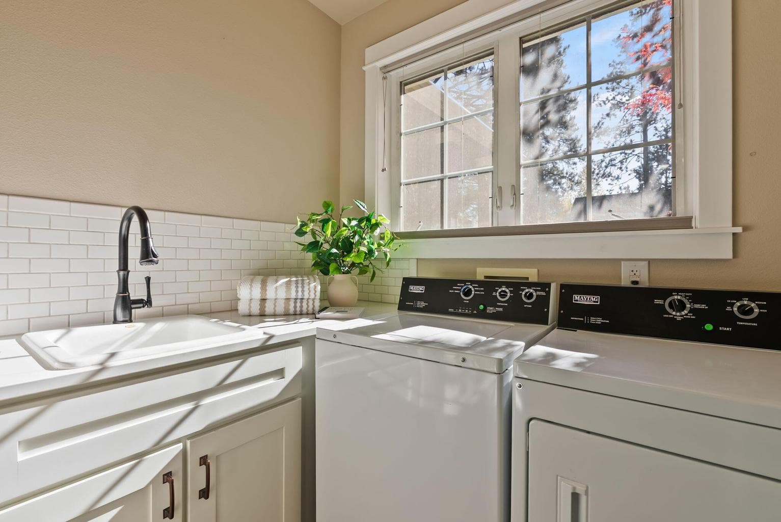 Laundry room with sink, folding counter, and commercial Maytag washer and dryer