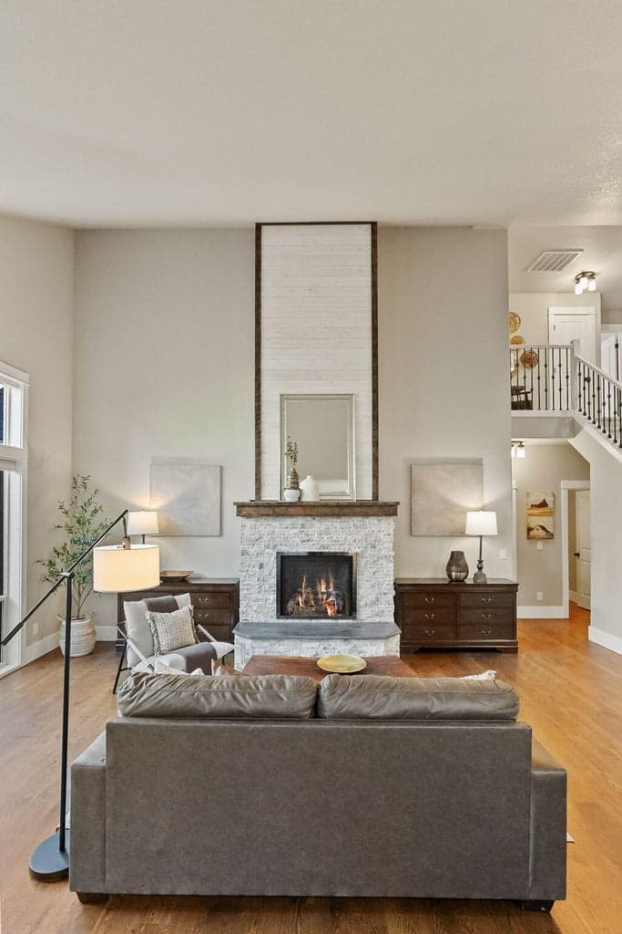 Floor to ceiling propane fireplace with stacked rock, wood mantle and farmhouse lap-style over-mantle