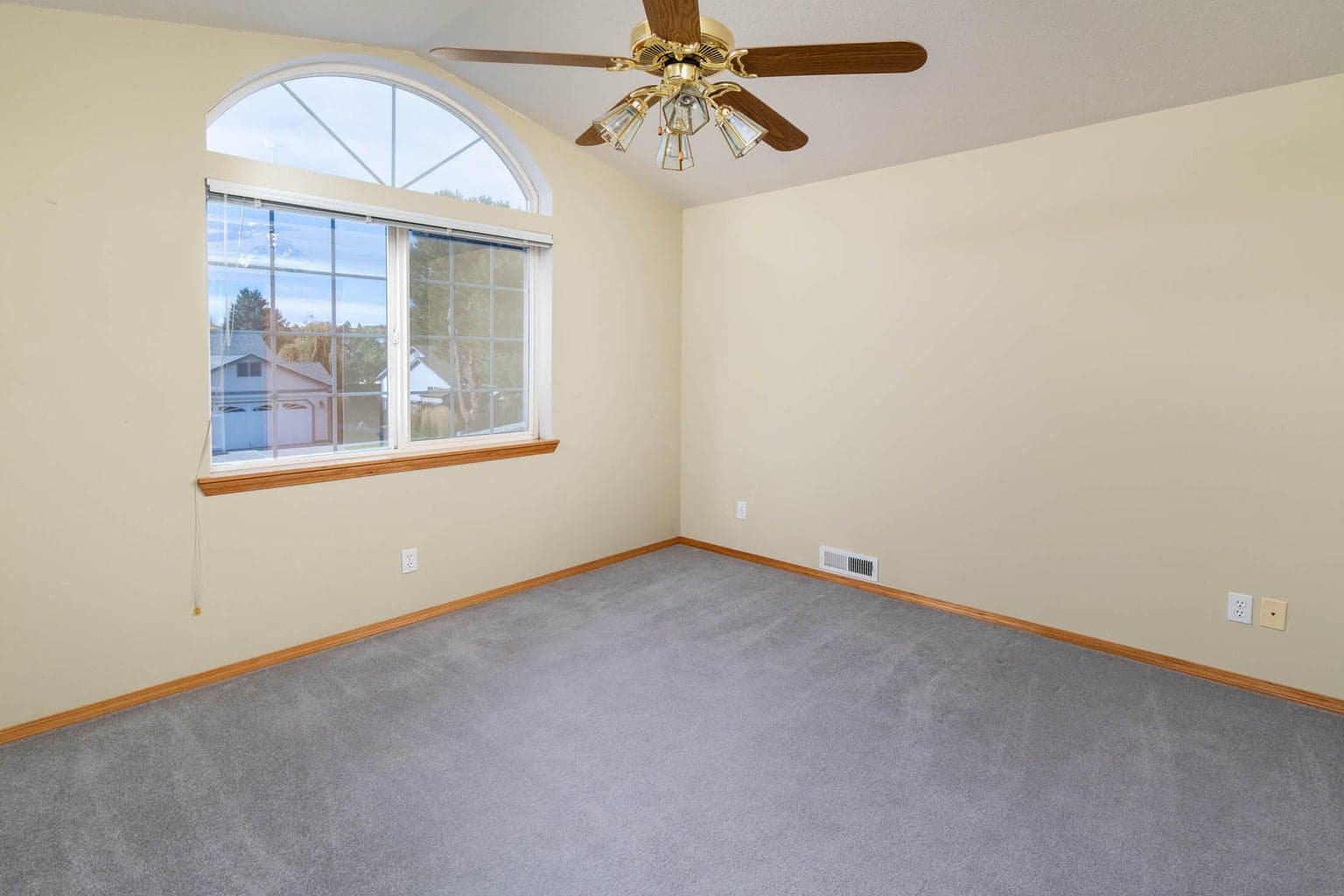 Vaulted guest bedroom w/ceiling fan, facing front of home