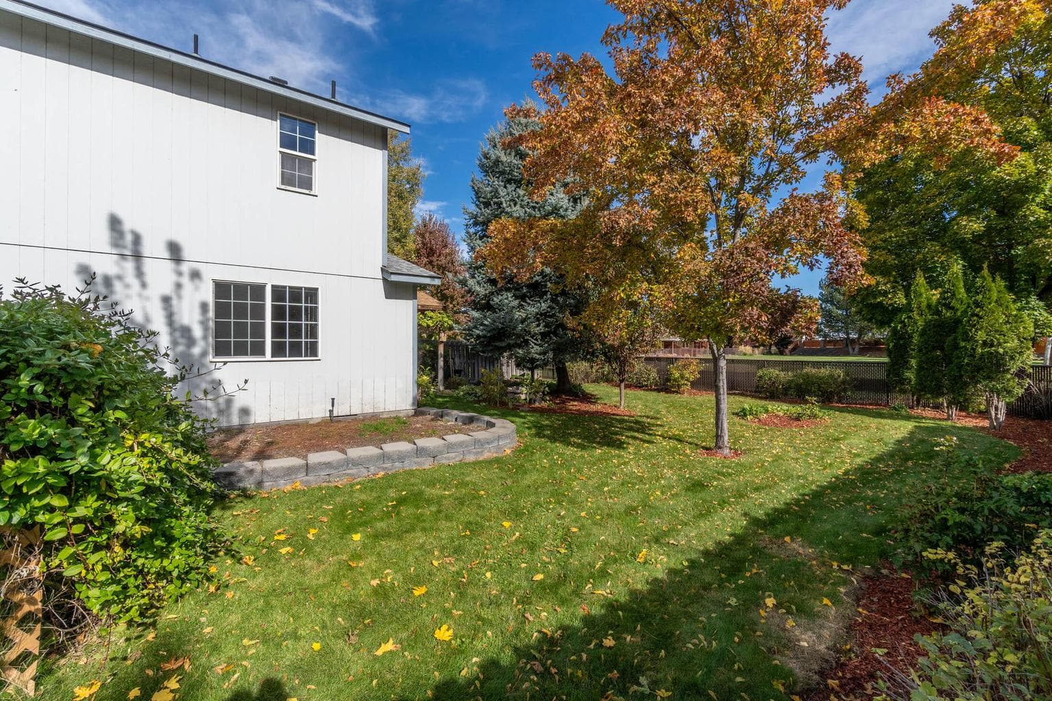 Large lot is fully fenced, includes mature landscaping, raised garden bed, auto sprinkler system