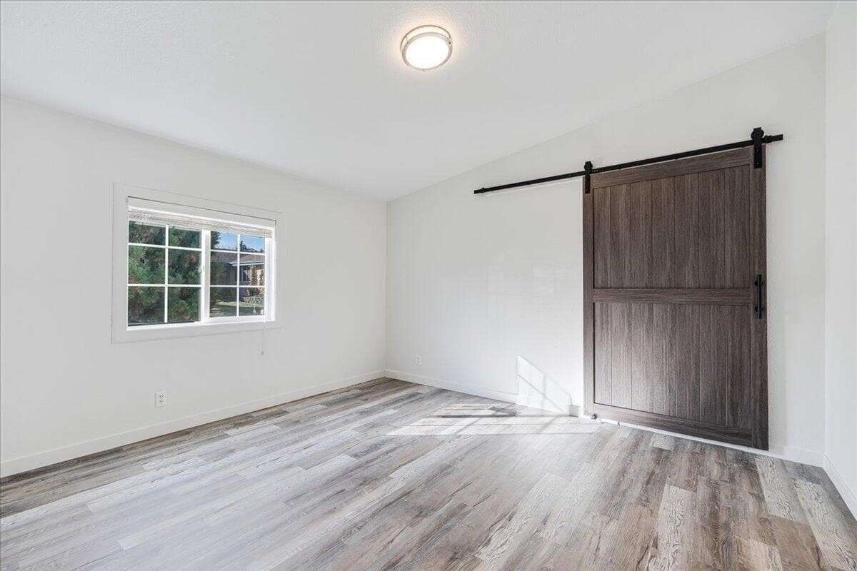 Primary bedroom with exit to garage hidden by barn door.