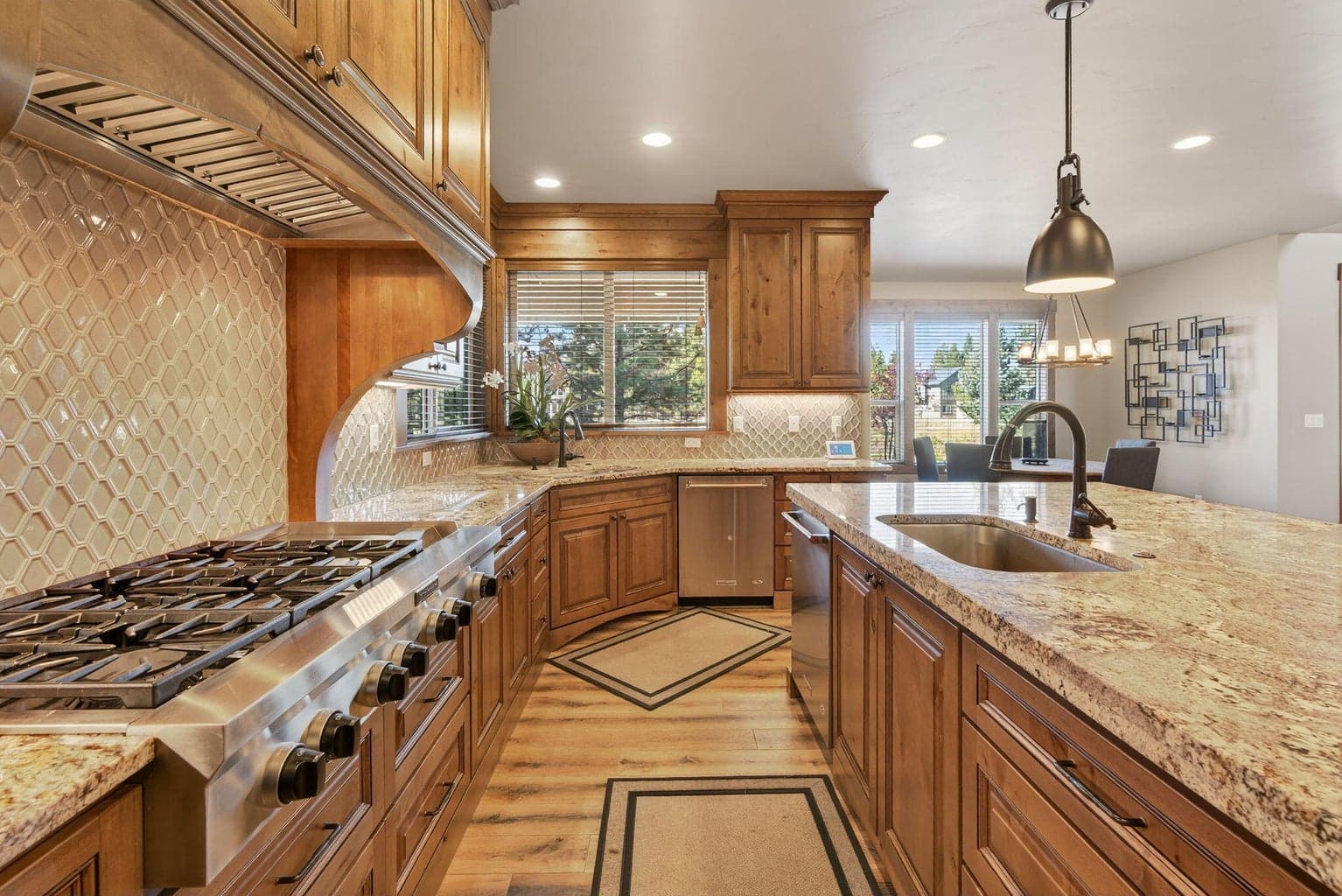 Showpiece kitchen features gleaming granite slab countertops, a spacious island breakfast bar, double ovens, a natural gas cooktop, dual dishwashers, and two deep sinks — perfect for entertaining or large gatherings. The cavernous side-by-side refrigerator and freezer, along with a generous walk-in pantry, provide abundant storage. Designed to inspire, this chef’s kitchen brings out your inner culinary master.