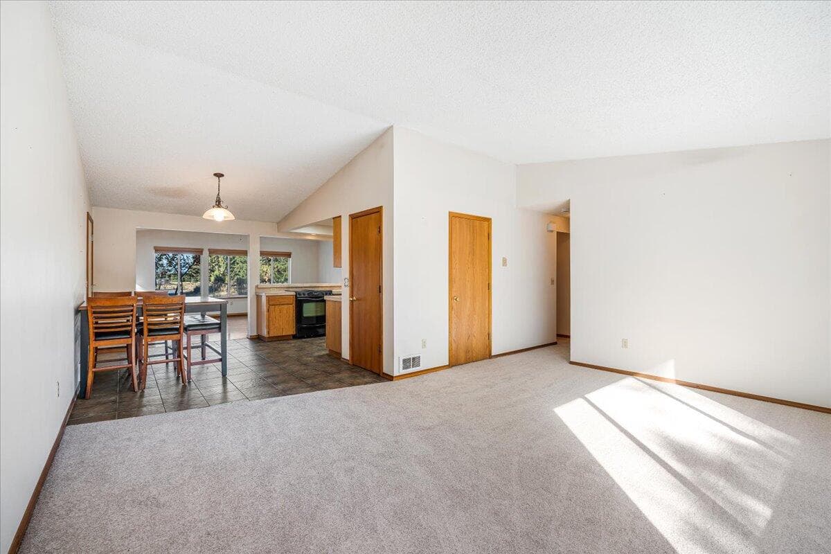 Enter into your living room with new carpet and vaulted ceiling