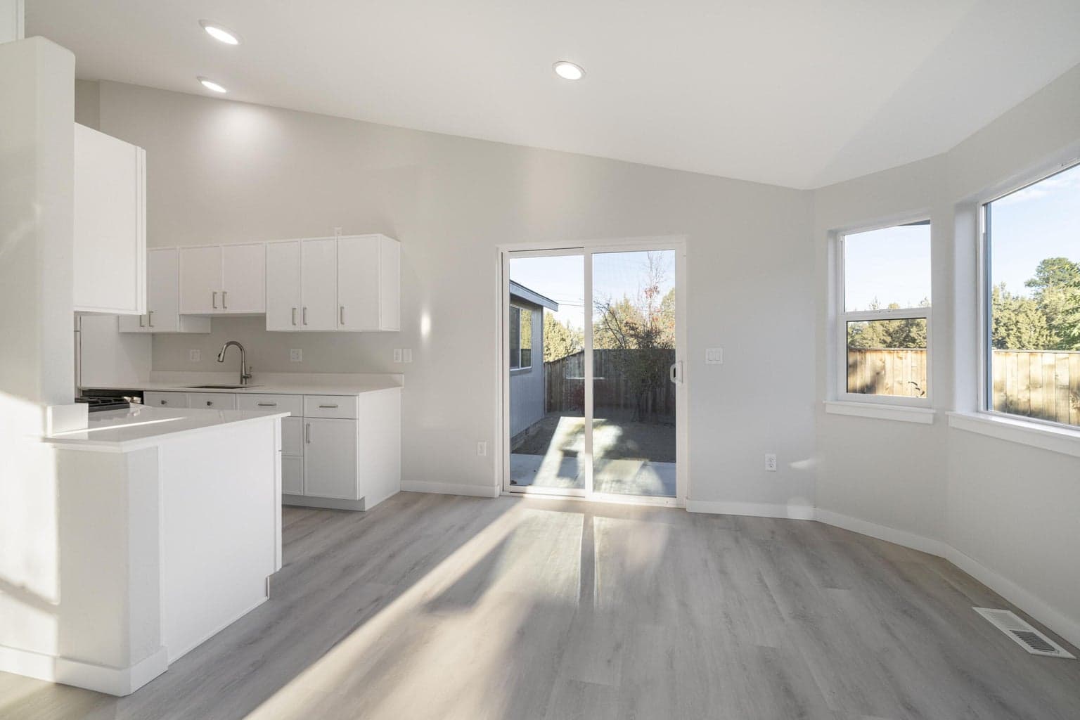 A view from the Great Room to the Dining Area to the Kitchen.