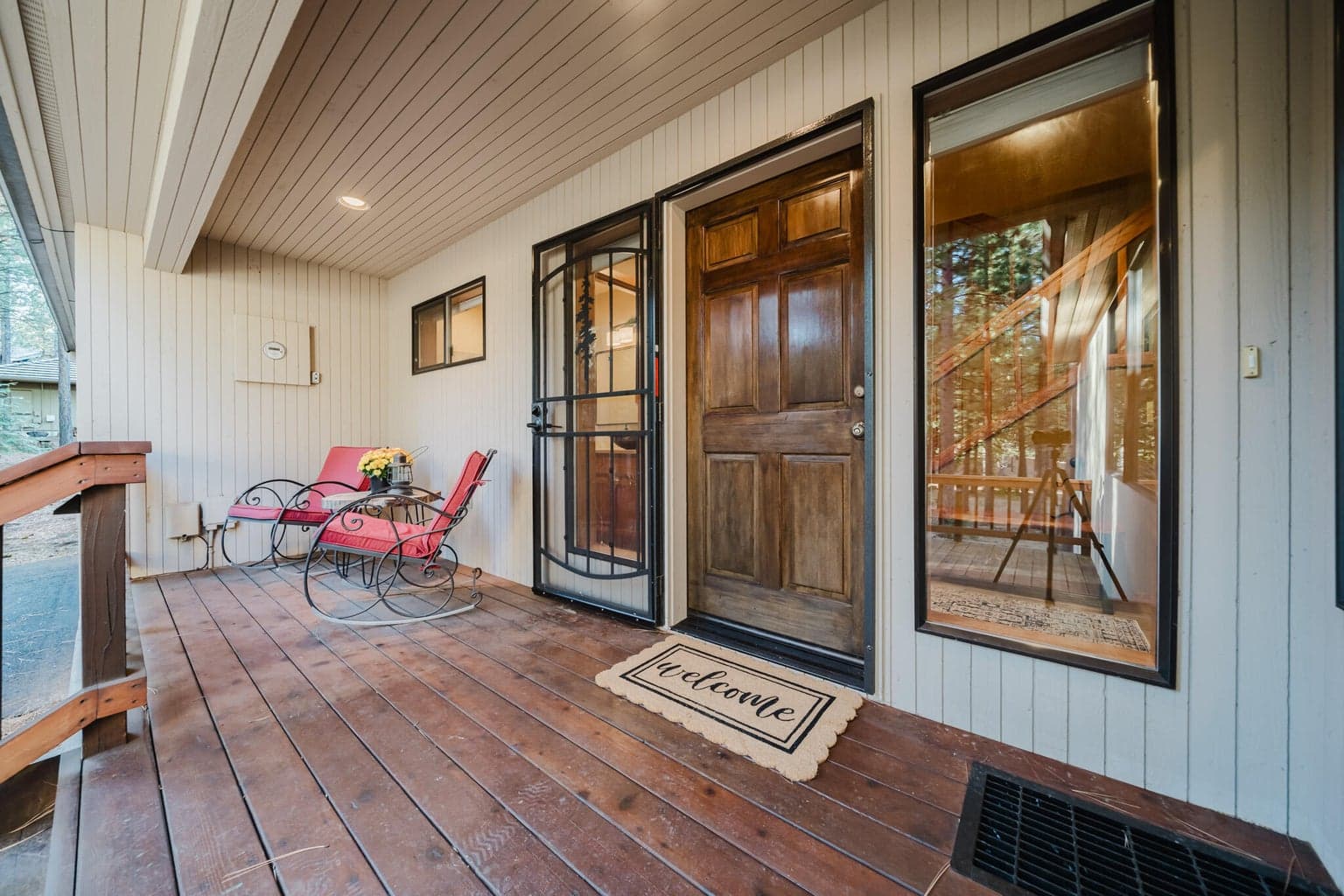 Covered entry deck, with locking metal screen door to allow air flow for the house seasonally.