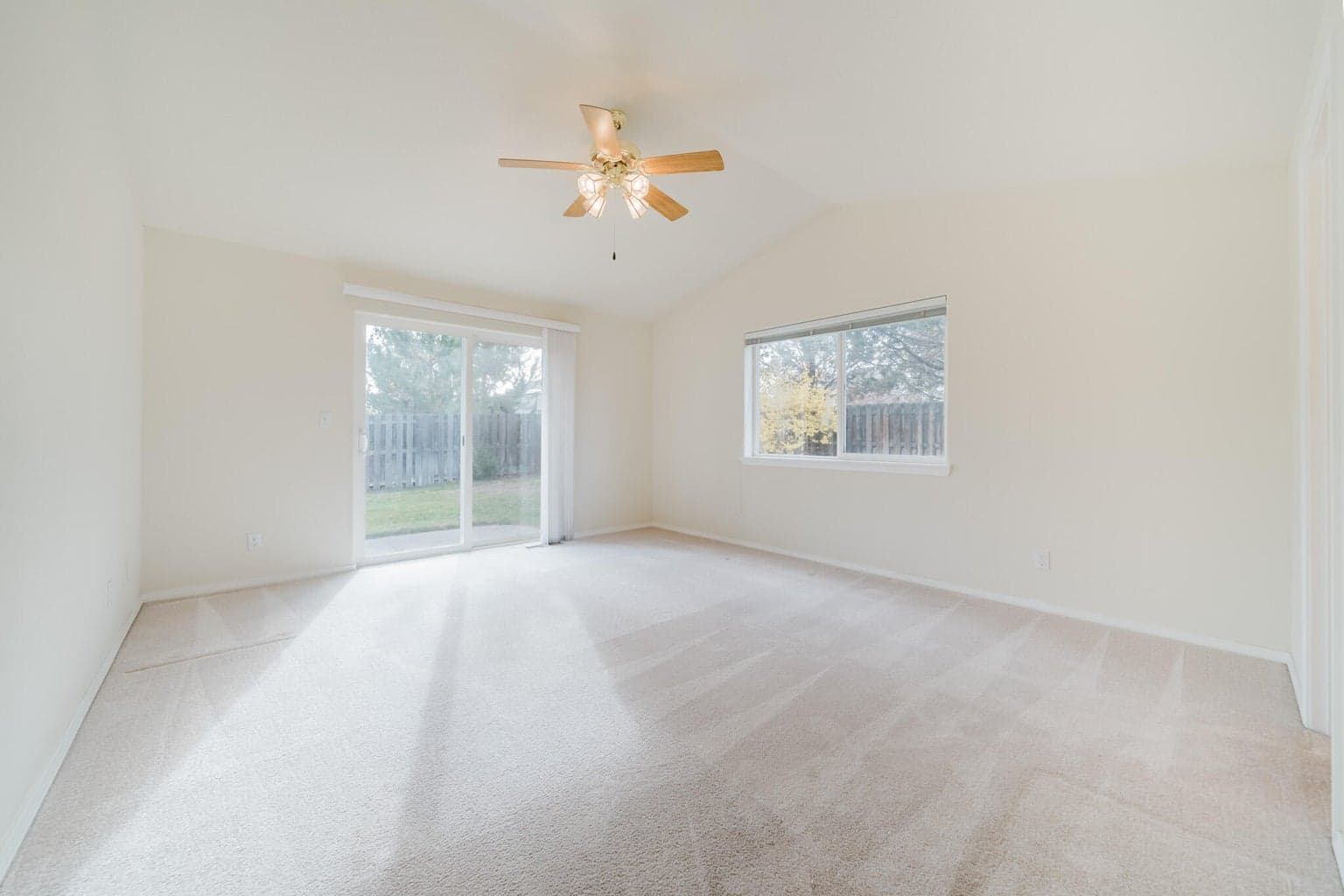 Sliding glass door leads to a concrete patio in the back yard.