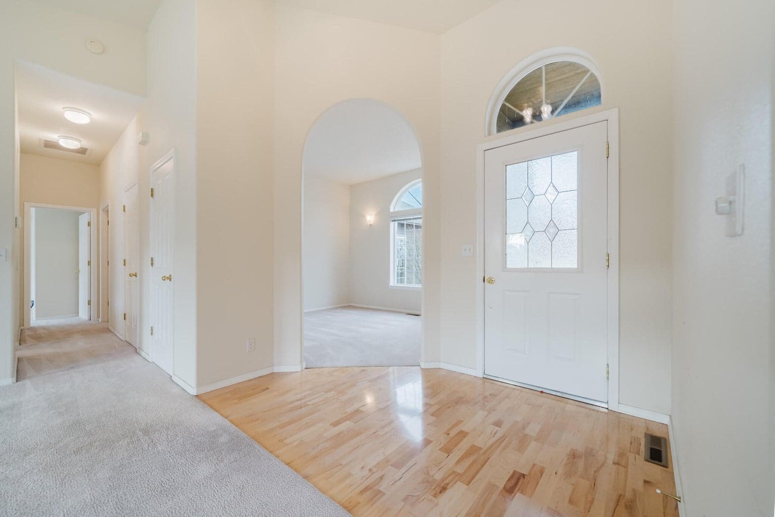 Front door and entrance to a flex room with an arched entry. Could be an office, TV room, craft or sewing room, of whatever you could use it as.