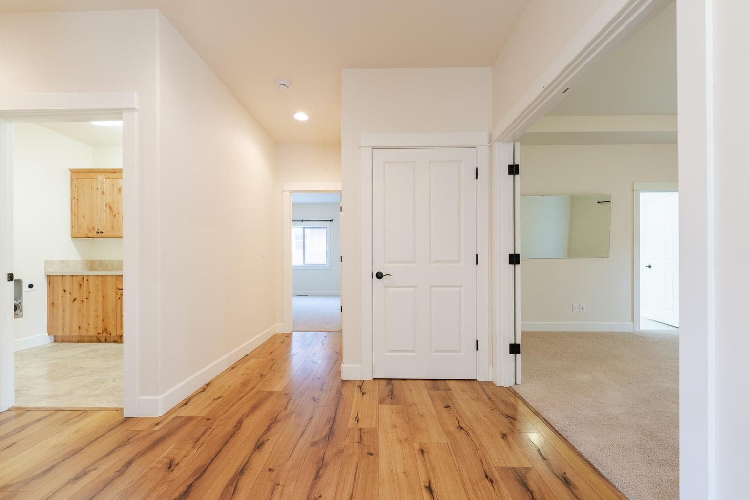 Main hallway enters to all bedrooms, laundry room, linen closet and garage