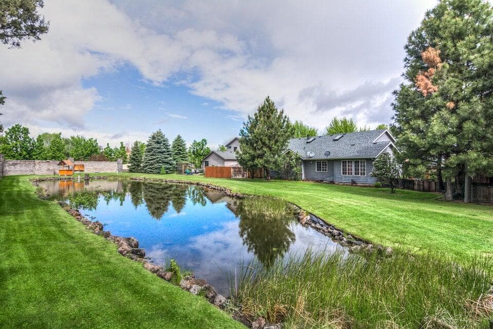 Backyard pond and lawn off the patio and views from the primary bathroom and Flex room