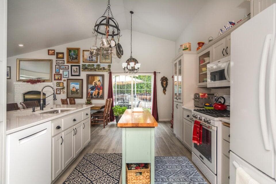 Kitchen with portable prep island, new white cabinets and appliances