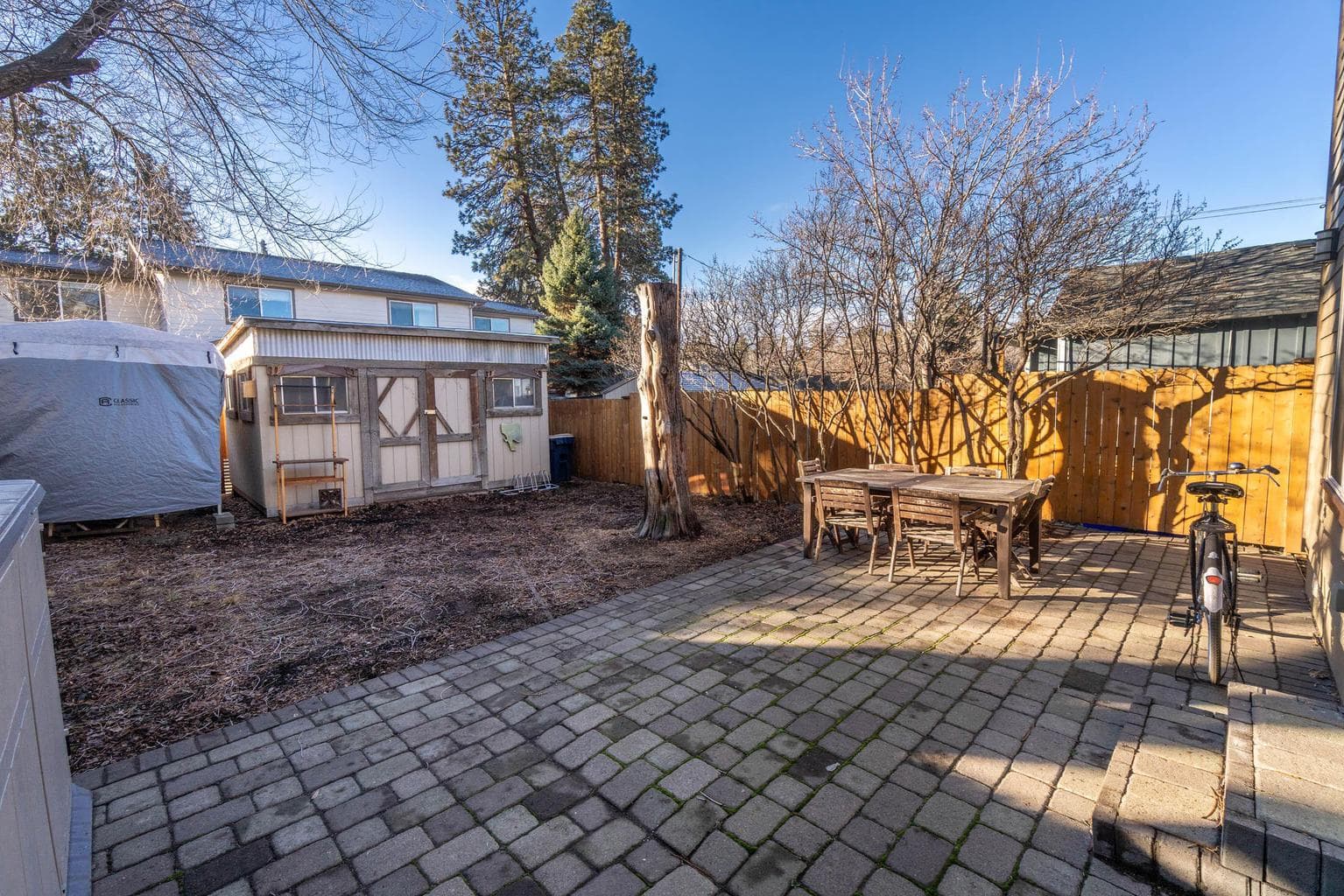 paver patio off the sliding door from the living room with storage shed and spacious yard