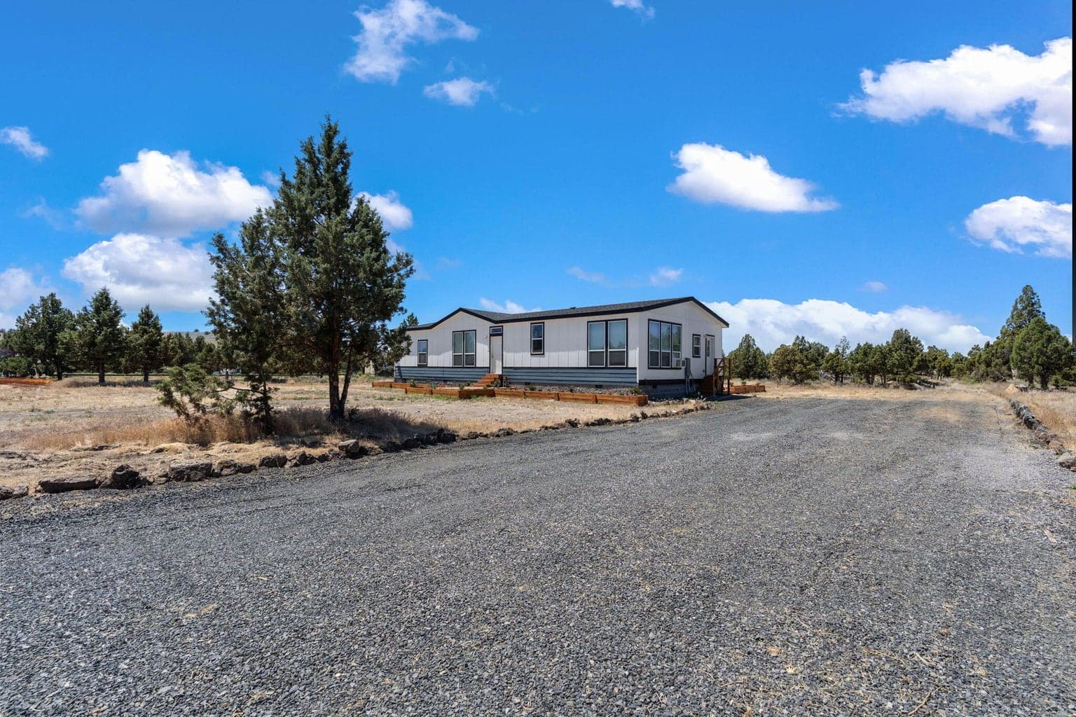 A long gravel drive leads to this modern, single-level residence nestled within a serene high desert landscape.