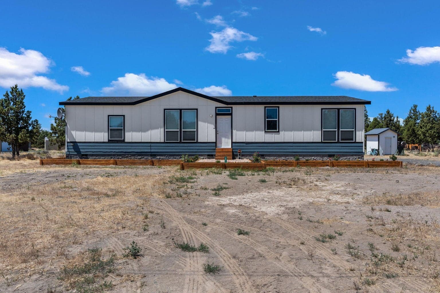 Modern single-level home set against a vast high desert landscape.