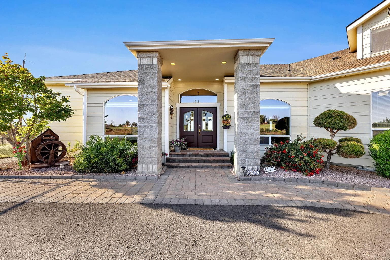 Impressive entryway with architectural columns, pavers and inviting landscaping.
