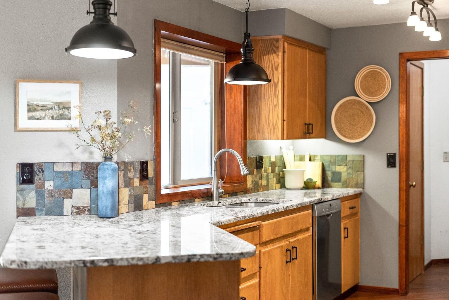 Open kitchen with granite counters, wood cabinets, stainless steel appliances, and simulated wood floors.