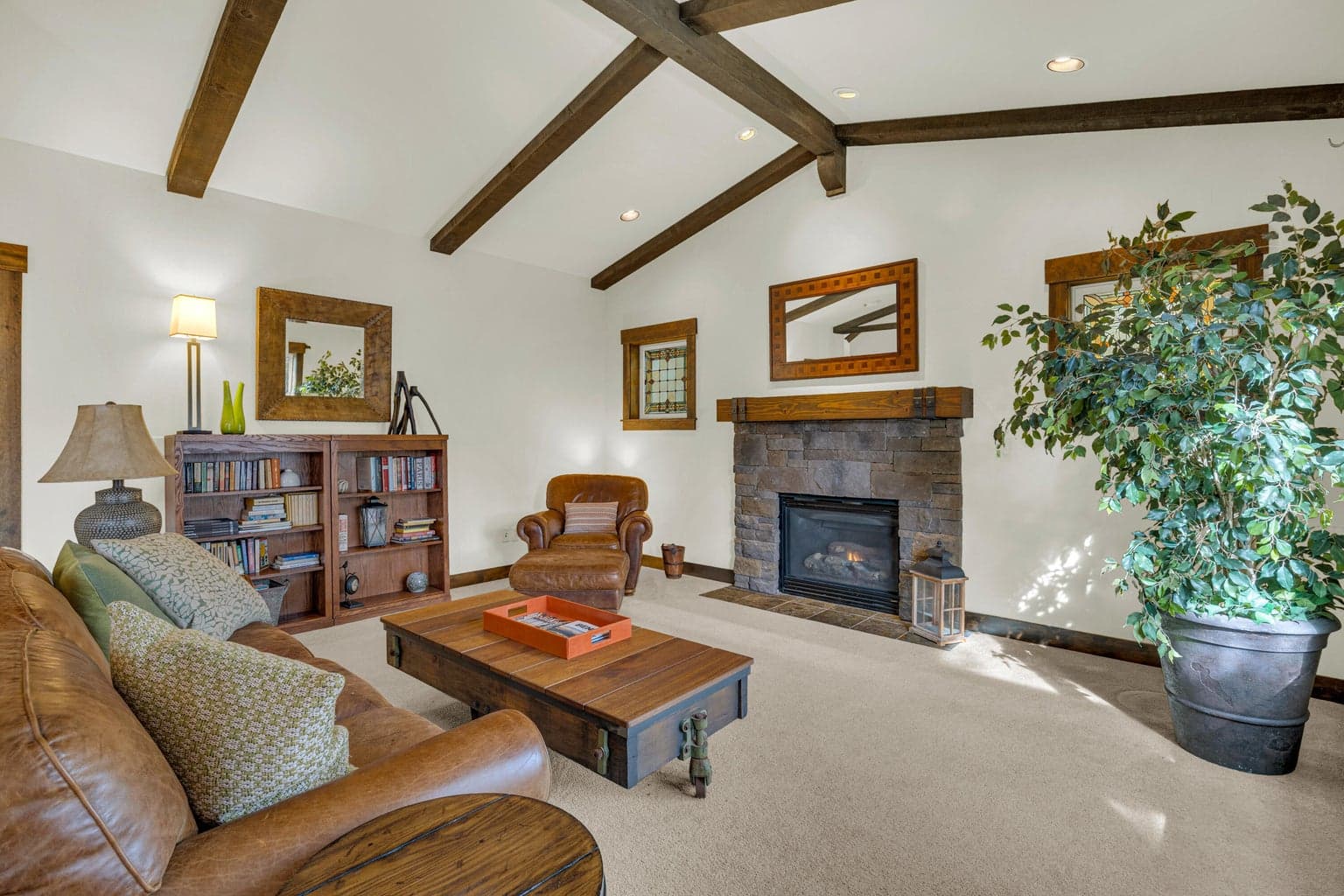Great room with fireplace and custom wood beam work.