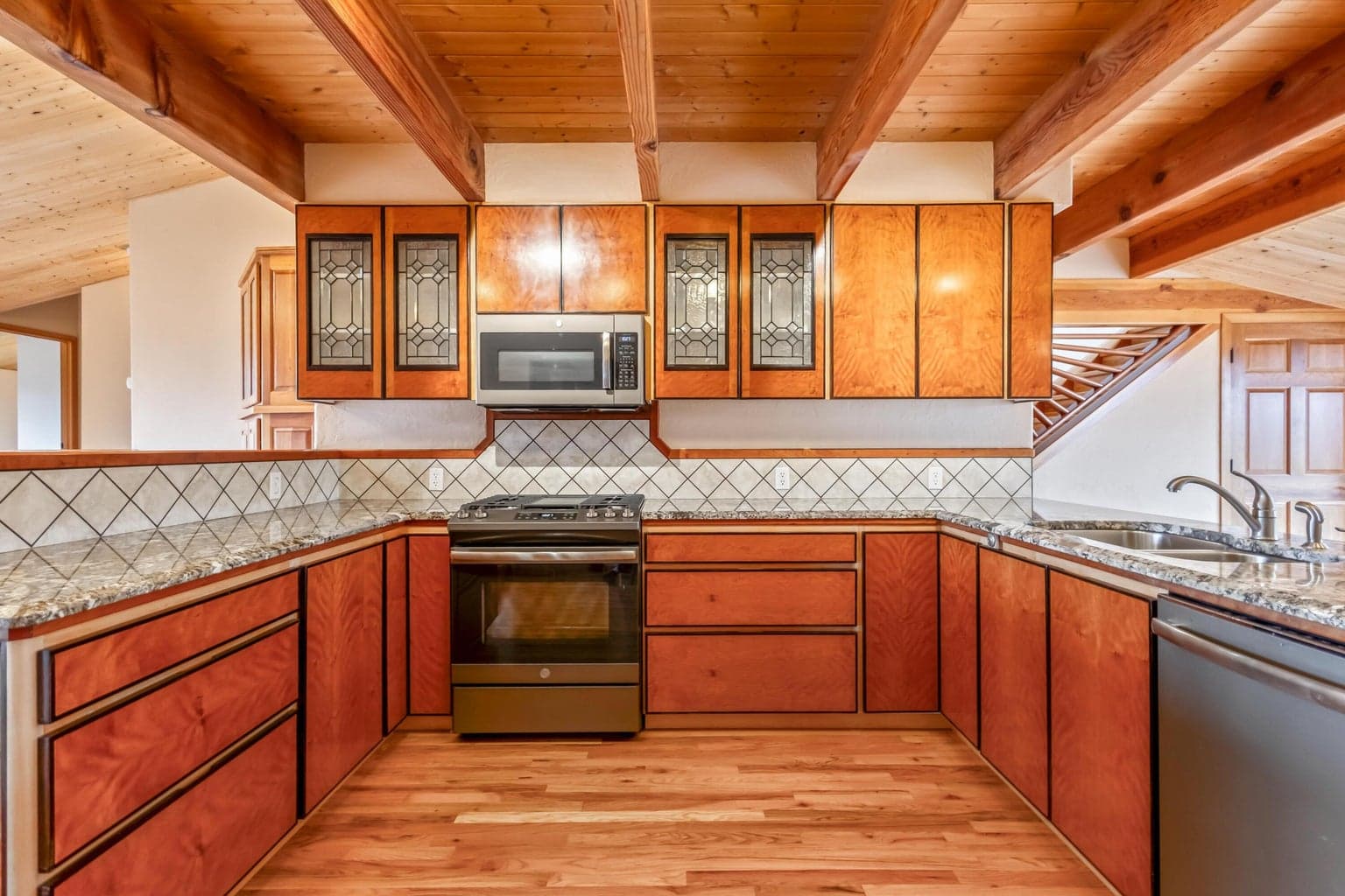 Kitchen with beams, wood flooring, custom cabinets, rose wood inlayed grout @backsplash