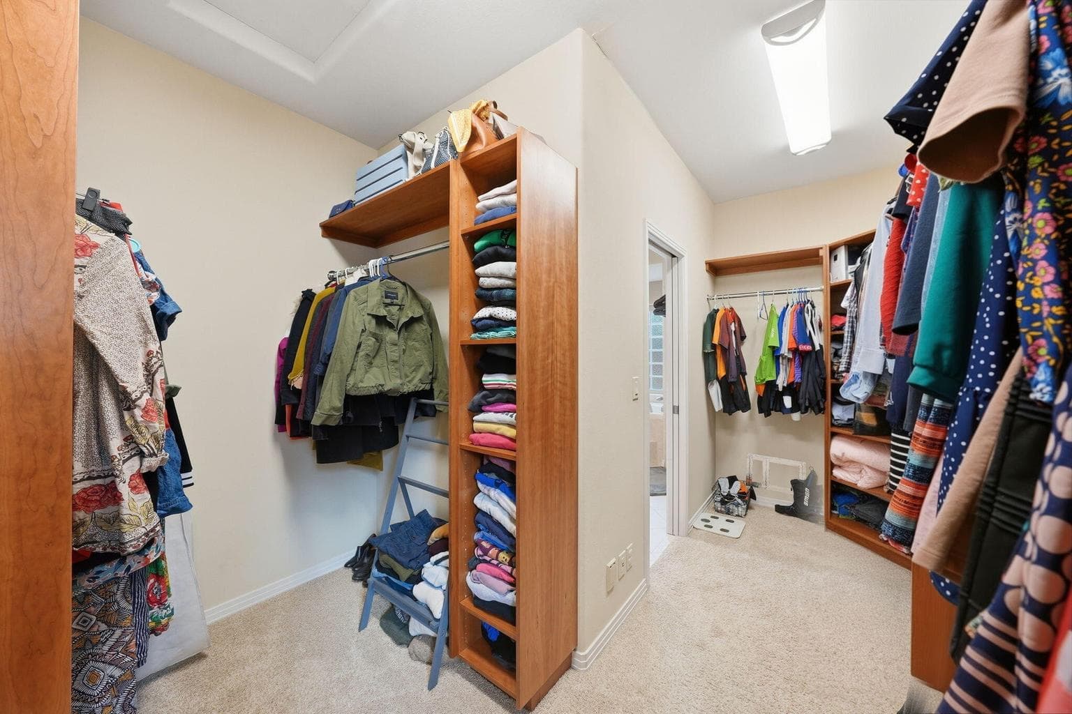 Spacious walk-in closet with built-in shelving and dresser