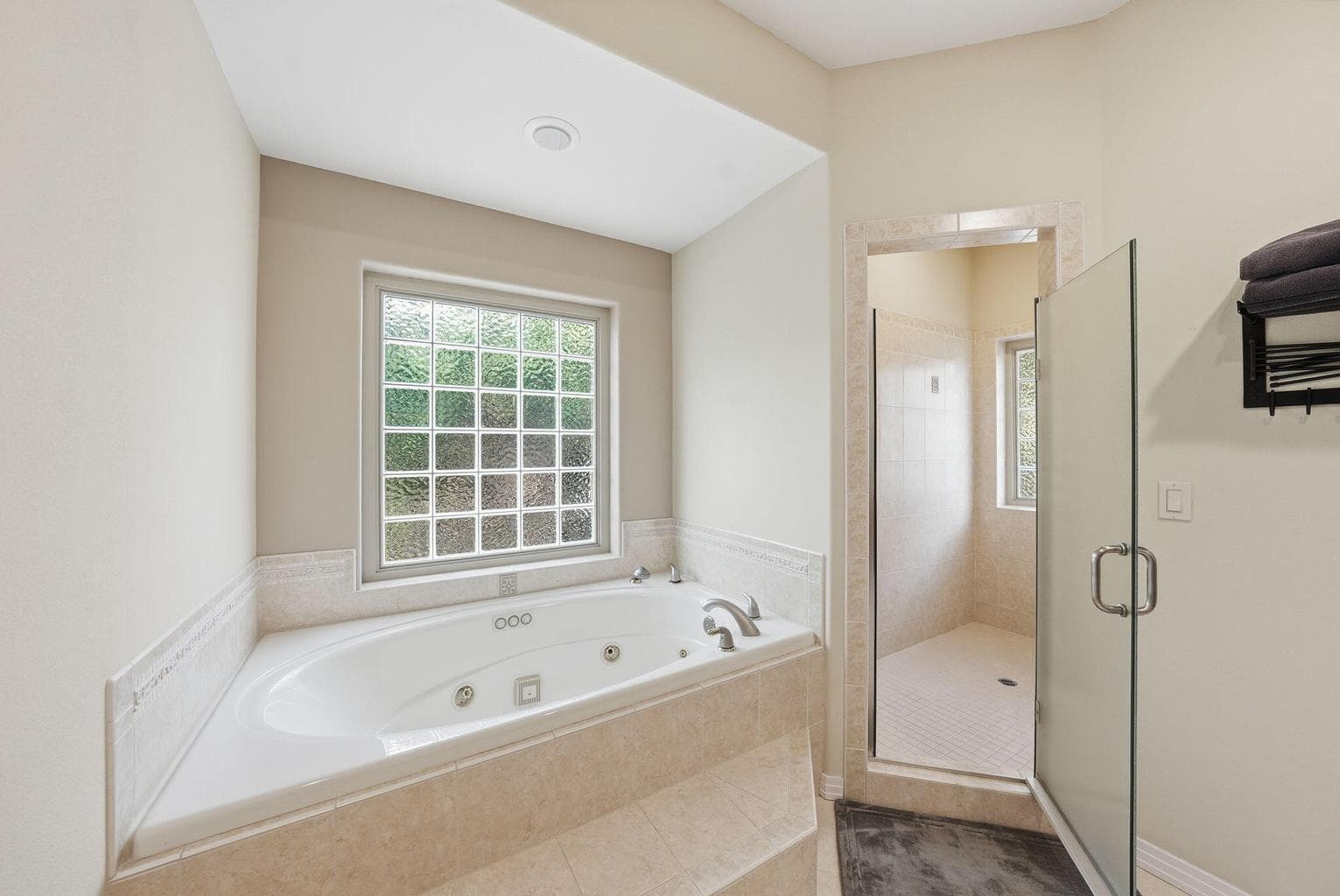 Jetted tub and walk-in shower with travertine tile