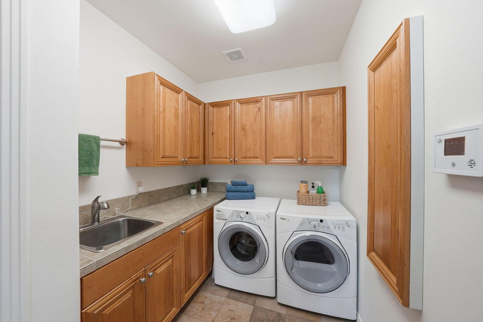 Laundry room with sink, cabinetry, linen closet & built-in ironing board, just off garage