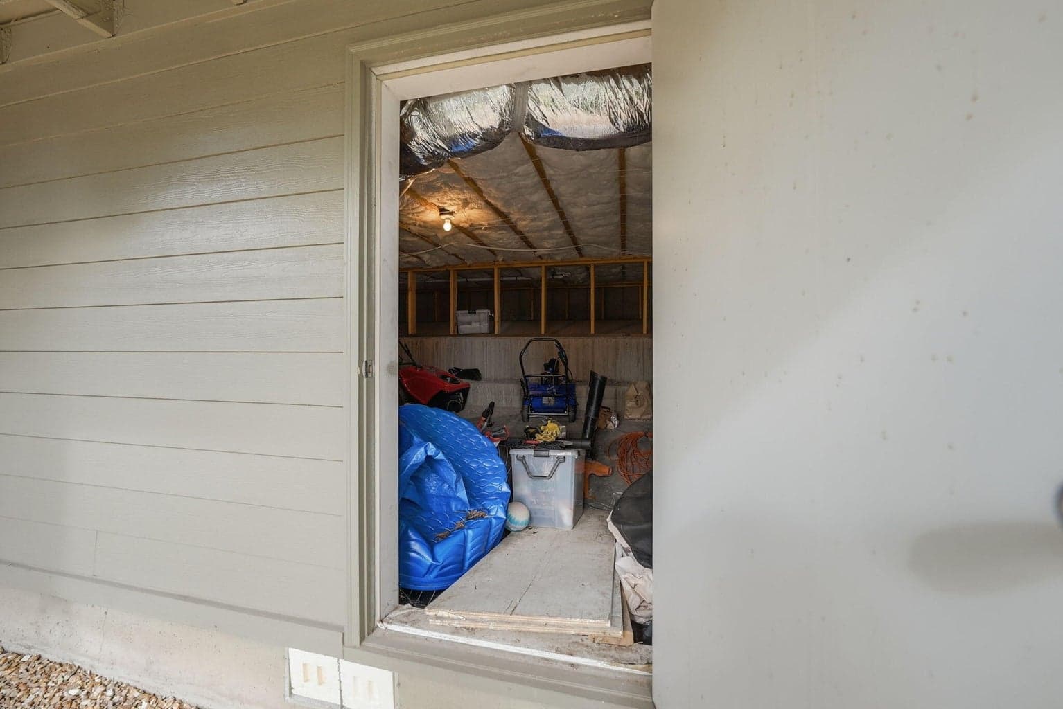 Large exterior storage room for patio furniture and yard equipment, not included in square footage