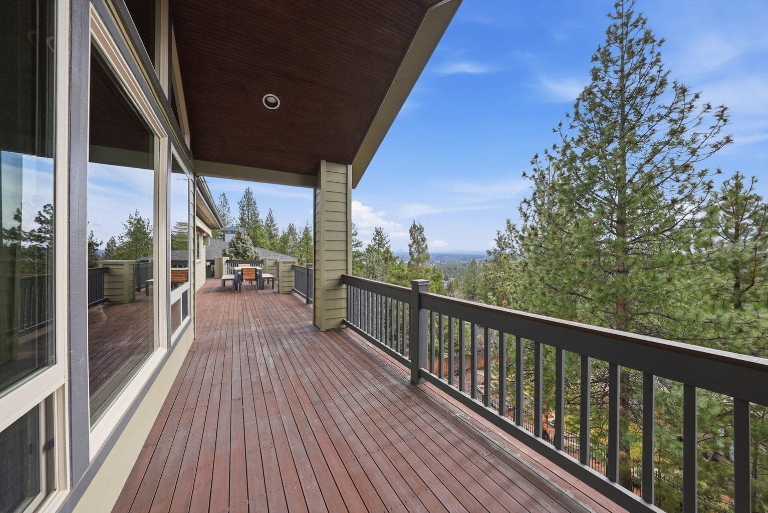 Sliding glass doors lead to the expansive mahogany deck, where covered and uncovered areas provide the perfect setting for entertaining in any season