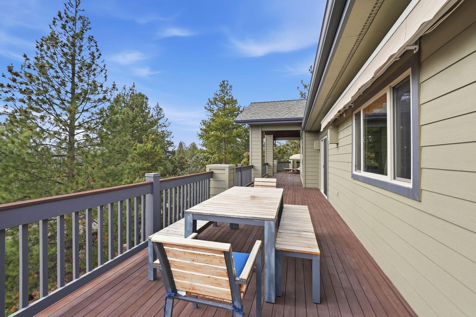 A remote-controlled awning provides shade at the touch of a button, while the home's sizable roof overhang offers additional protection from the sun, creating a comfortable outdoor living space throughout the day.