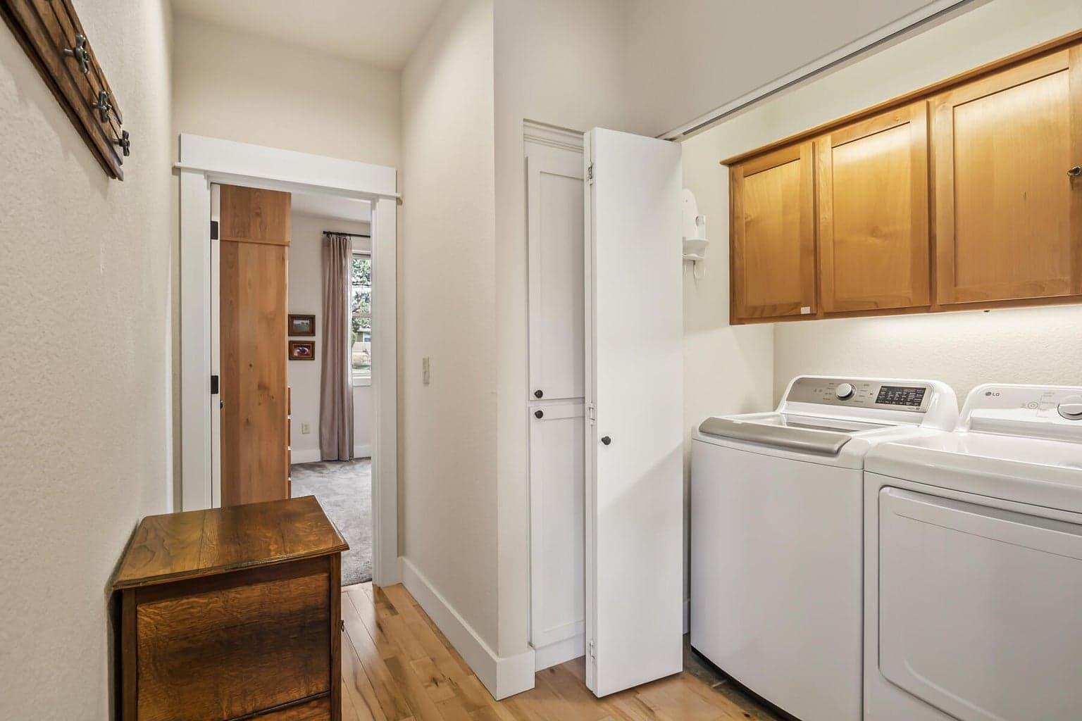 Newer washer and dryer tucked conveniently along a light-filled hallway