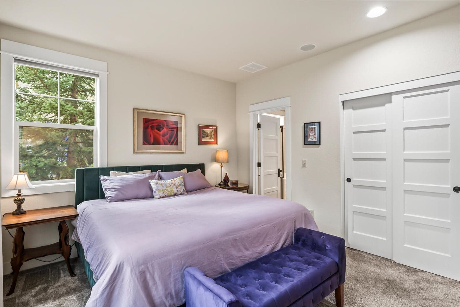 Tranquil primary bedroom overlooking lush backyard green space and trees
