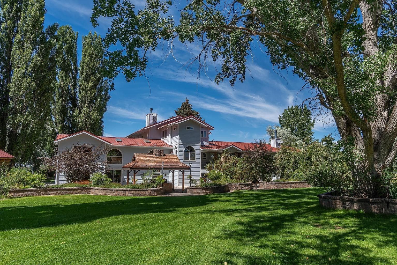 Rear view of home with meticulously maintained yard