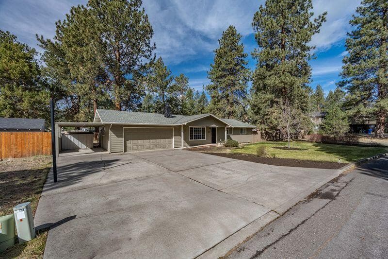 Big driveway in front of the 2 car garage and additional carport.