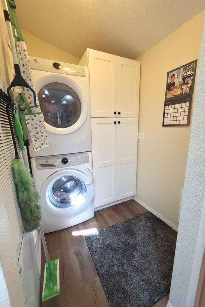Newly renovated laundry room with full size washer/dryer and storage cabinet