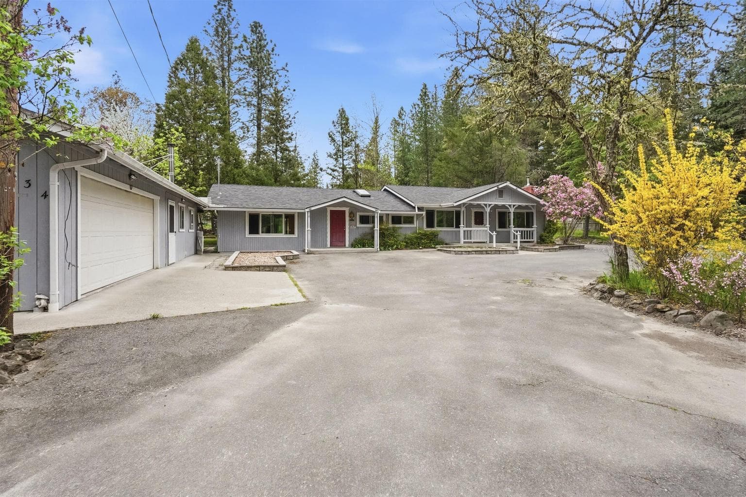 The main house is in the center. Attached yet separate, on the left is a tidy ADU and attached 2 car garage with a workshop.