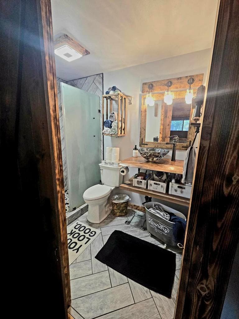Master bathroom. Custom walk-in tiled shower. Custom sink. and tile flooring.