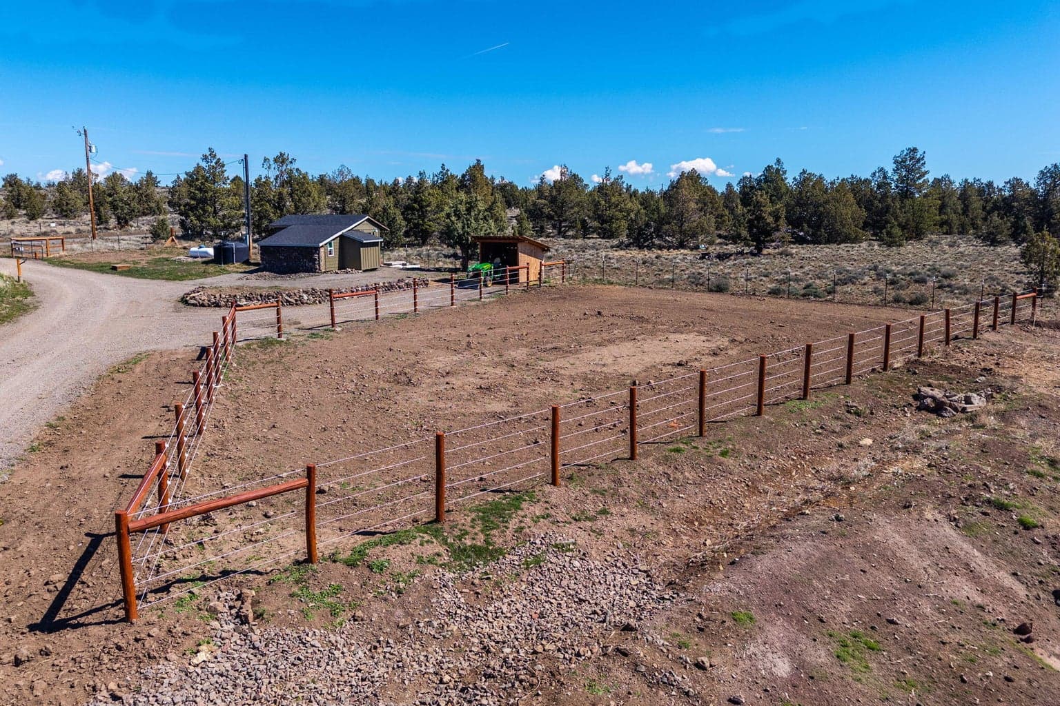 Fenced are with electric fencing in place. Water and hay shed in place