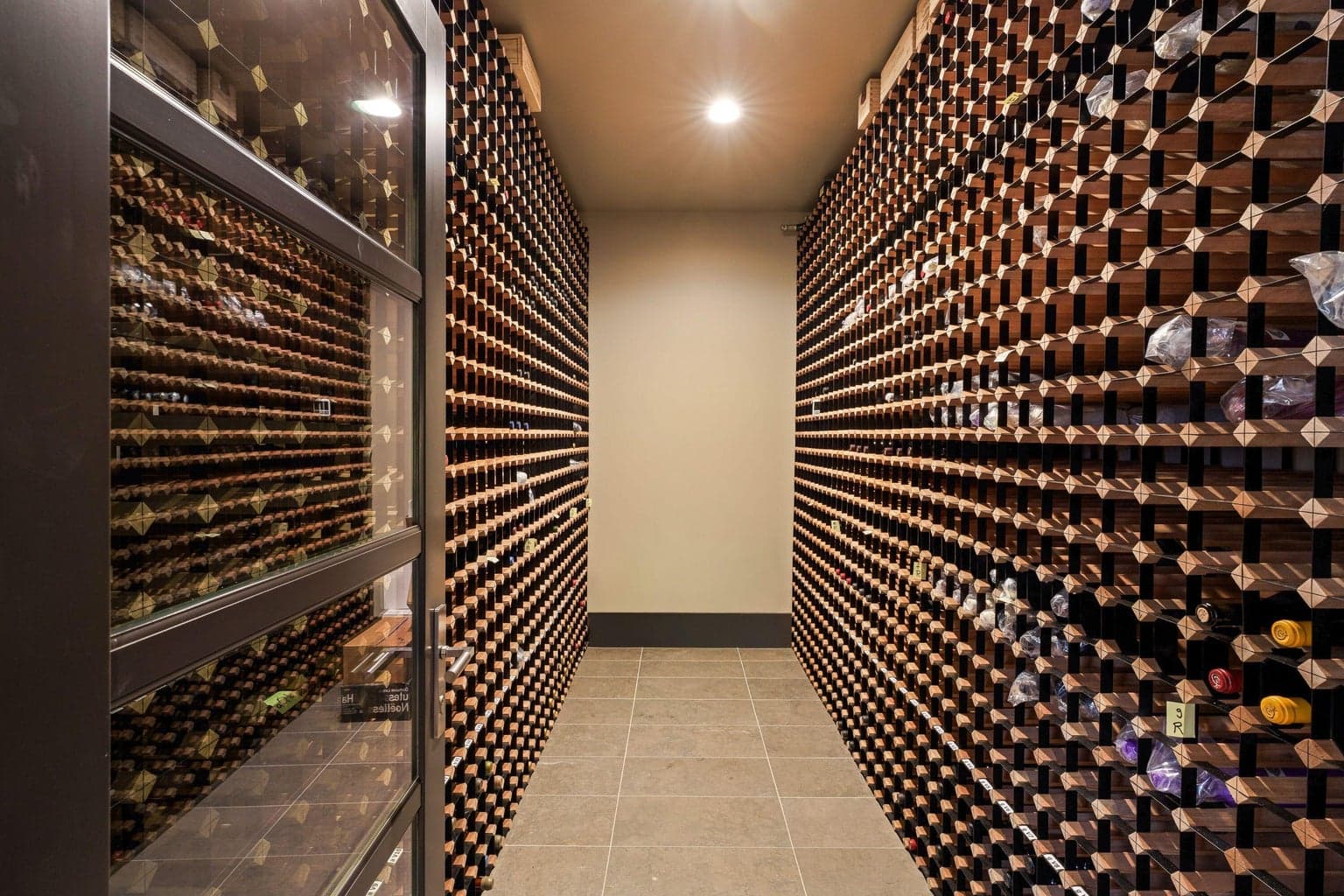 Temperature-controlled wine room with custom racking for over 4,000 bottles (including magnums), designed for both storage and display.