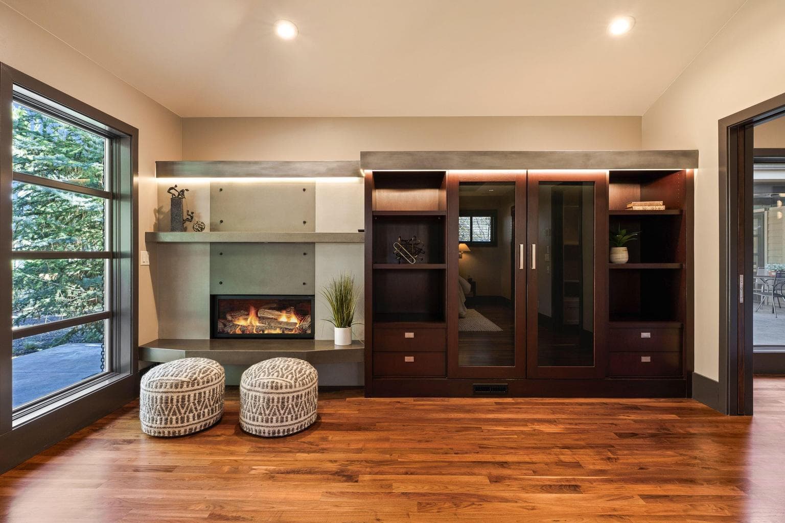 Primary suite with a concrete fireplace surround and custom built-ins, combining clean design with functional storage.