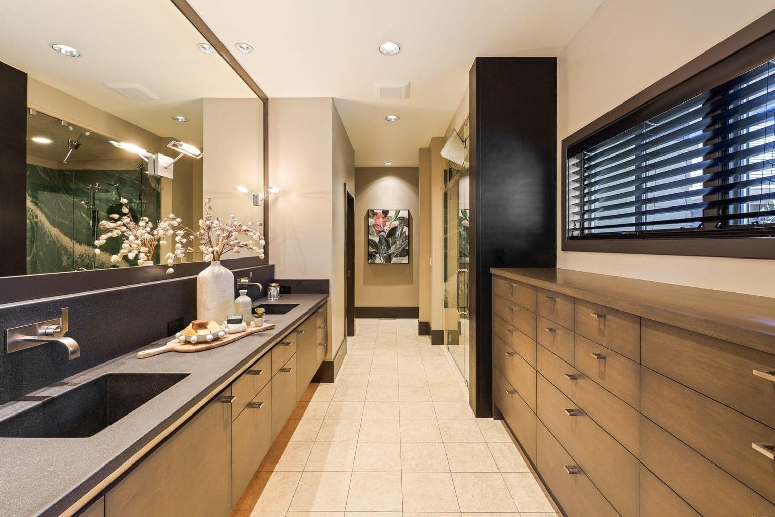 Spacious primary bath with dual vanities, custom concrete countertops with integral sinks, abundant drawer storage, and a walk-in shower.
