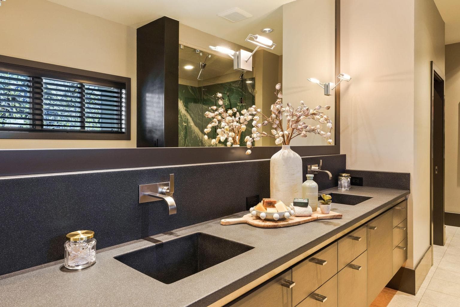 Custom dual vanity with concrete countertops, integral sinks, wall-mounted fixtures, and extensive drawer storage.
