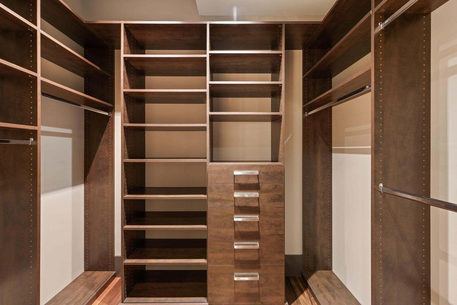 Custom walk-in closet with built-in shelving, drawers, and hanging space for easy organization.