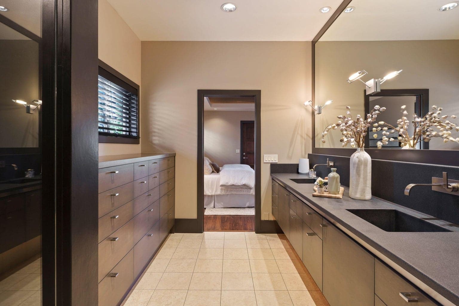 Primary bath with dual vanities, custom concrete countertops, and extensive drawer storage, thoughtfully connected to the primary suite.