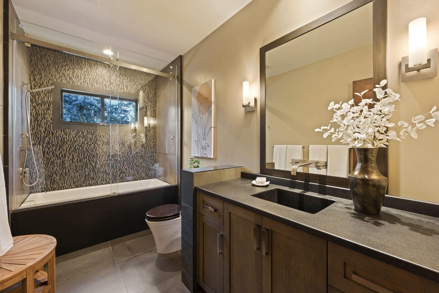 Stylish guest bath serving the flex space or guest suite, featuring a tiled shower/air-tub tub combo, modern vanity with solid surface counters, and a clean, contemporary finish.