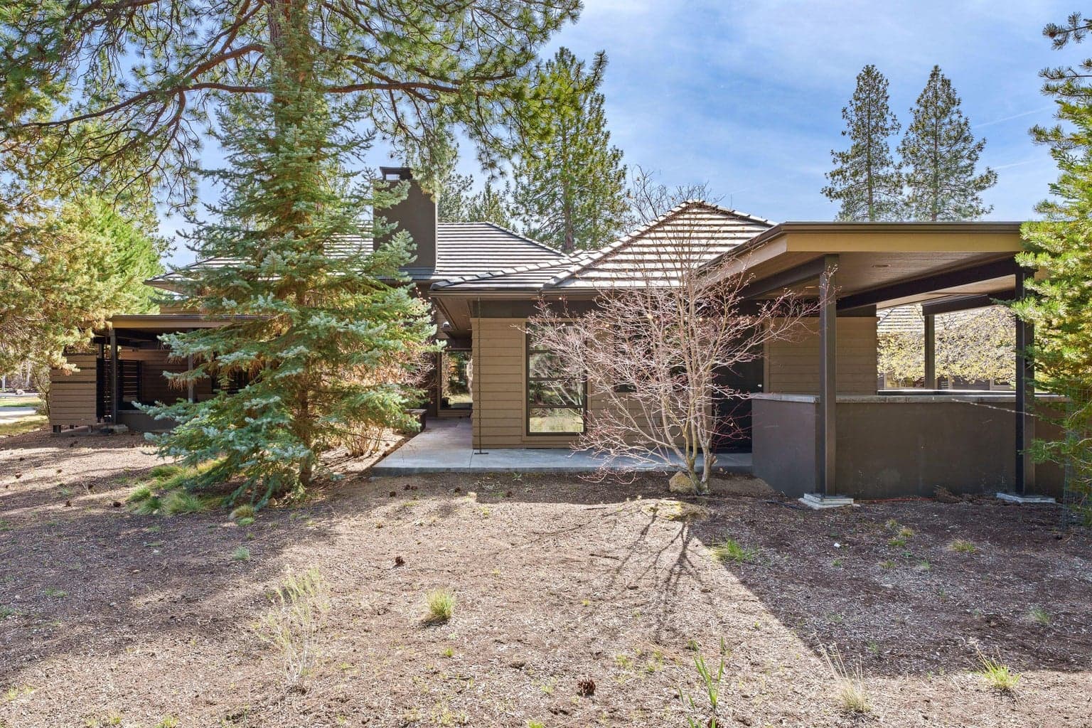 Thoughtfully designed to embrace the outdoors, the home is tucked among mature trees with covered patios and a private courtyard that extend the living space into the landscape.