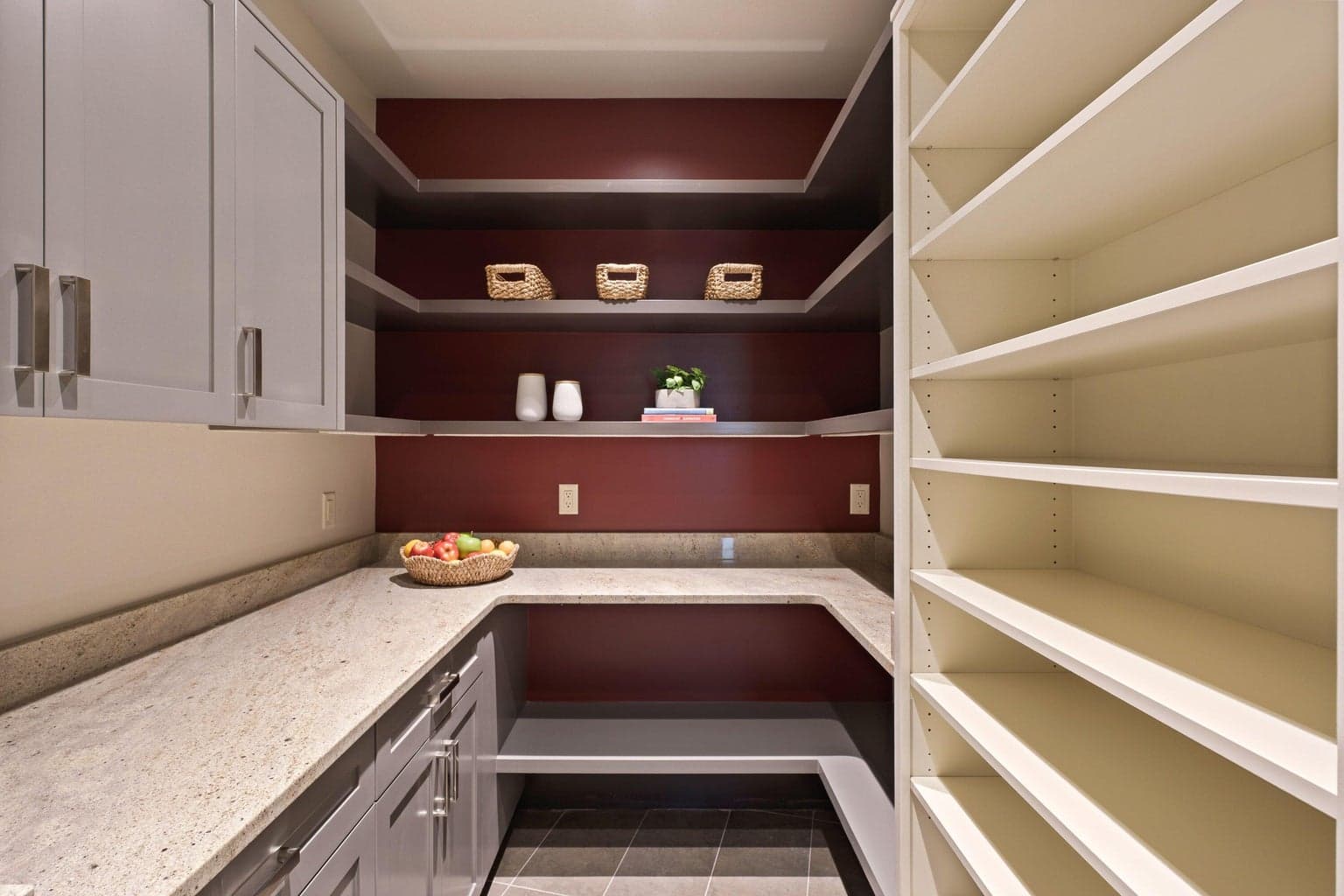 Generous walk-in pantry with extensive shelving, countertop workspace, and room for an additional refrigerator—ideal for storage, prep, and keeping the kitchen beautifully uncluttered.
