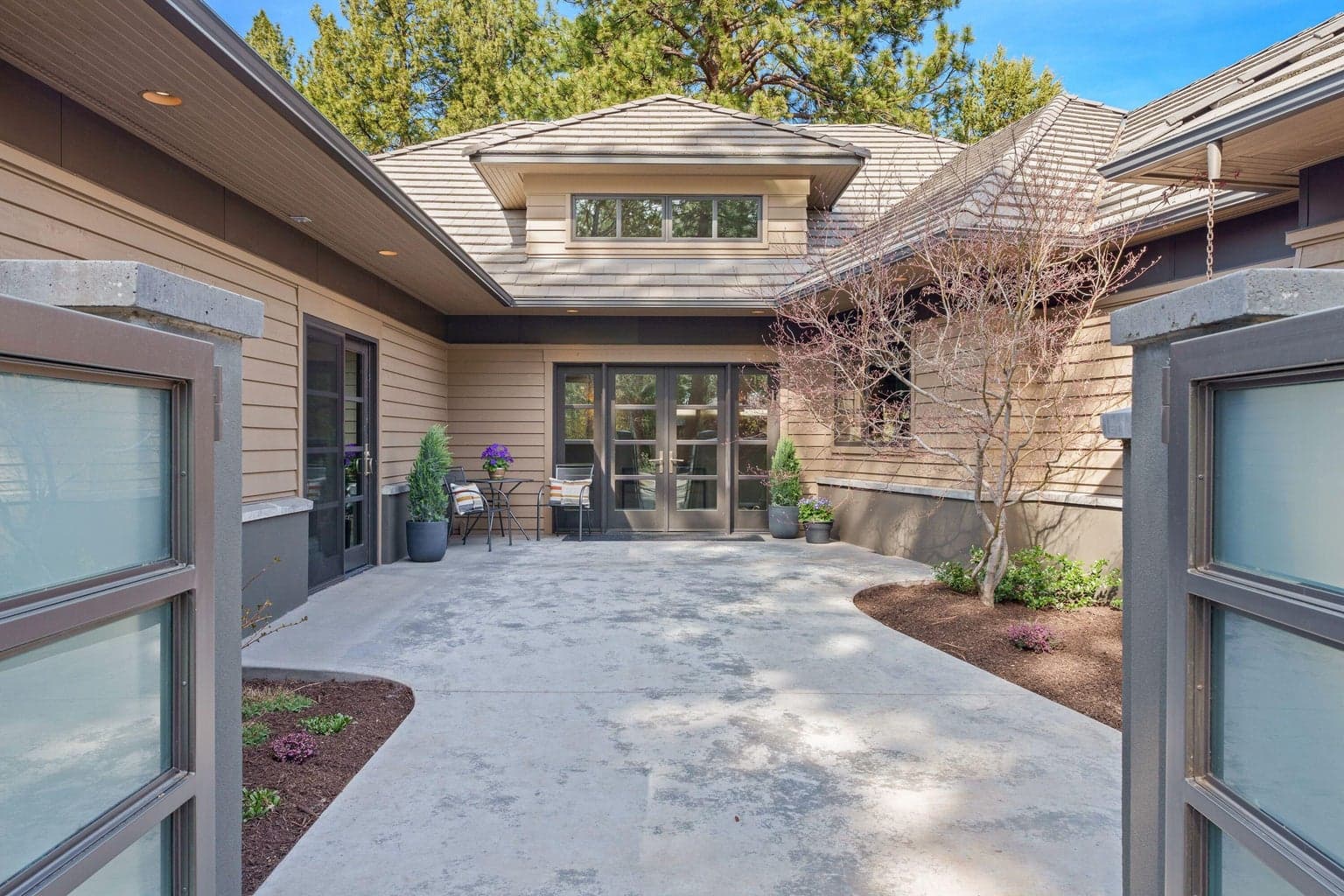 A welcoming courtyard entry creates a private, sheltered approach—complete with a heated slab for year-round comfort.