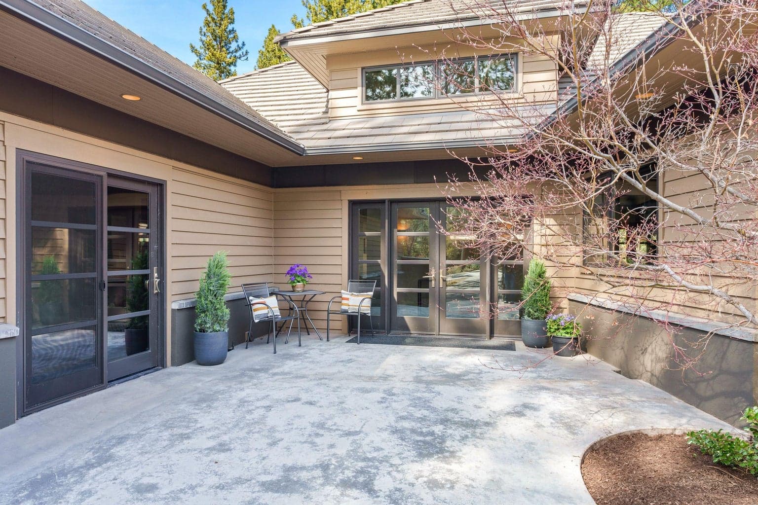 A private, sheltered courtyard welcomes you in, complete with a heated slab for year-round comfort. Framed by soft landscaping and warm architectural details, it’s an inviting space to pause before stepping inside.