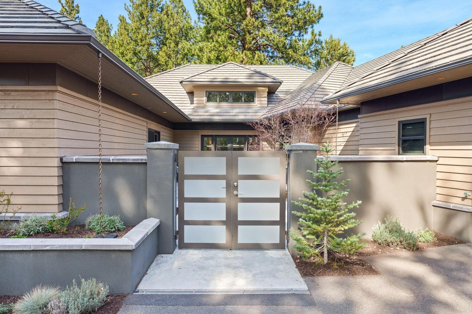 Custom entry gates create a striking first impression while adding an extra layer of privacy and security to the courtyard approach.