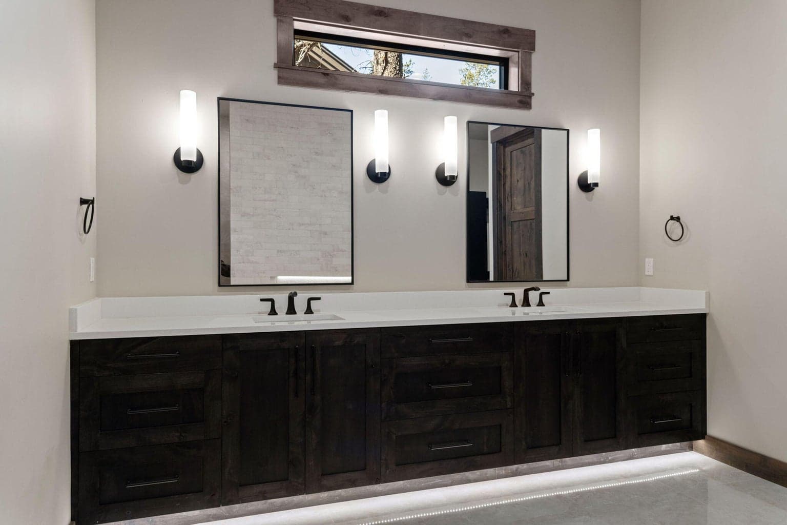 Main level Primary ensuite bathroom boasts heated tile floors and dual vanity and solid surfaces throughout