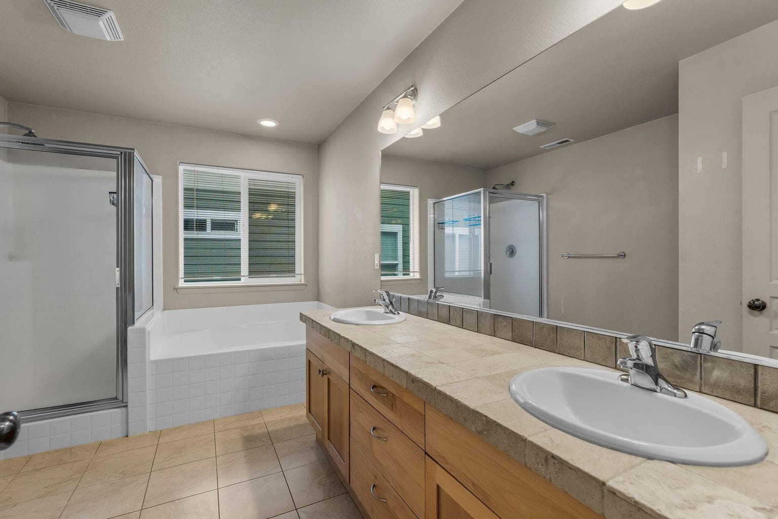 Primary bathroom with dual vanities and a large soaking tub.