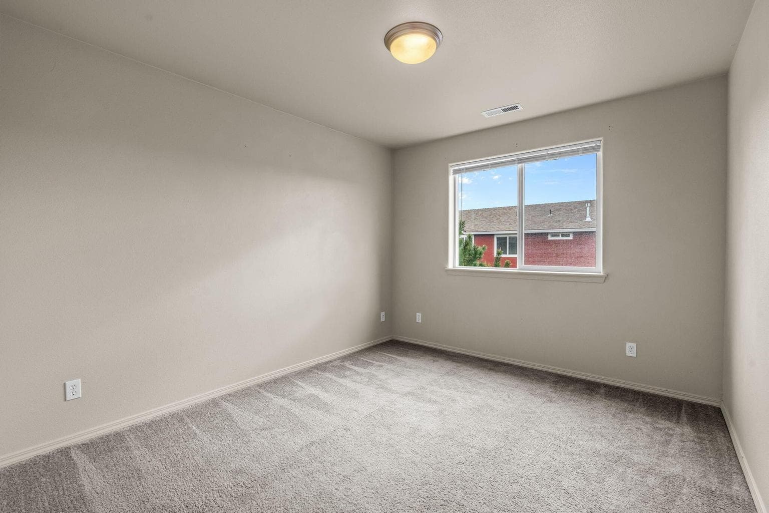 The third bedroom, bright and currently styled as a guest room.